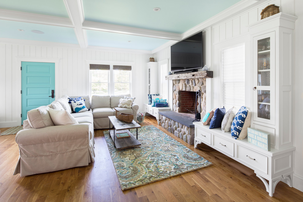 Offenes, Großes Maritimes Wohnzimmer mit weißer Wandfarbe, braunem Holzboden, Kamin, Kaminumrandung aus Stein, TV-Wand und braunem Boden in Boston