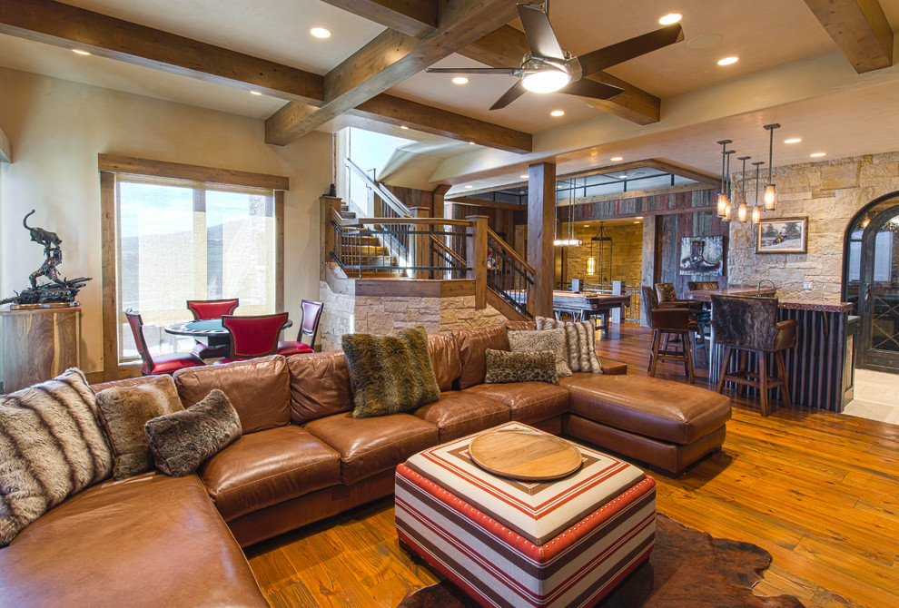 Immagine di un grande soggiorno chic aperto con sala giochi, pareti beige e pavimento in legno massello medio
