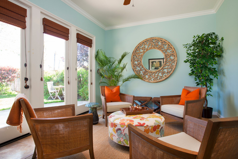 Inspiration for a mid-sized tropical enclosed travertine floor family room remodel in San Diego with blue walls and no fireplace