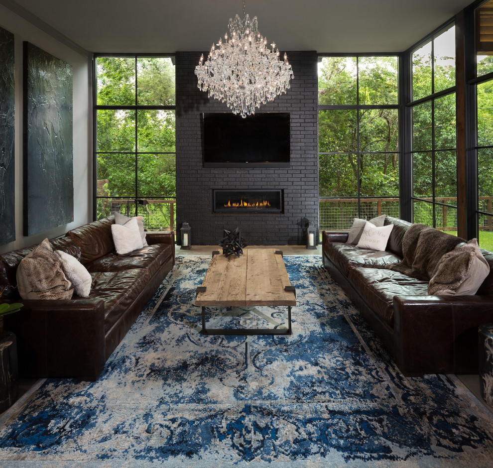 Inspiration for a large industrial open concept concrete floor and gray floor family room remodel in Dallas with gray walls, a ribbon fireplace, a brick fireplace and a wall-mounted tv