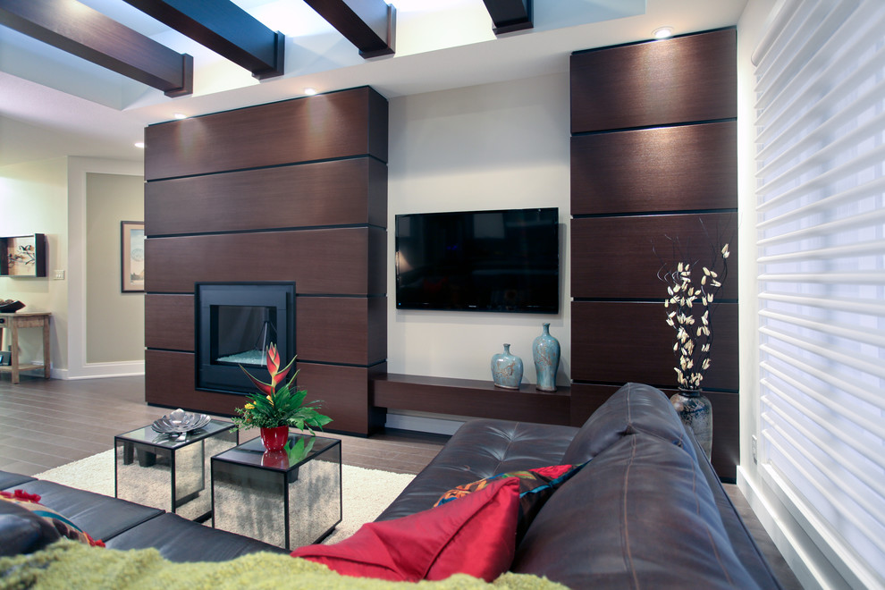 Свежая идея для дизайна: большая открытая гостиная комната в современном стиле с темным паркетным полом, стандартным камином, телевизором на стене, белыми стенами и фасадом камина из дерева - отличное фото интерьера
