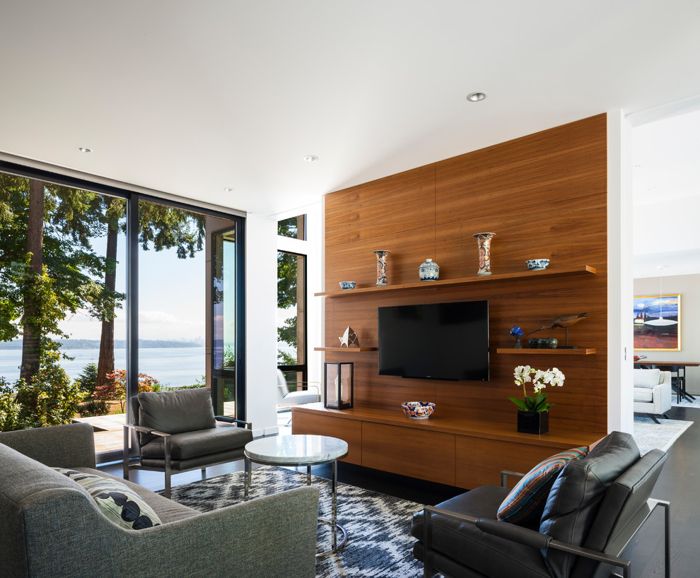 Example of a trendy open concept dark wood floor and black floor family room design in Seattle with white walls and a wall-mounted tv