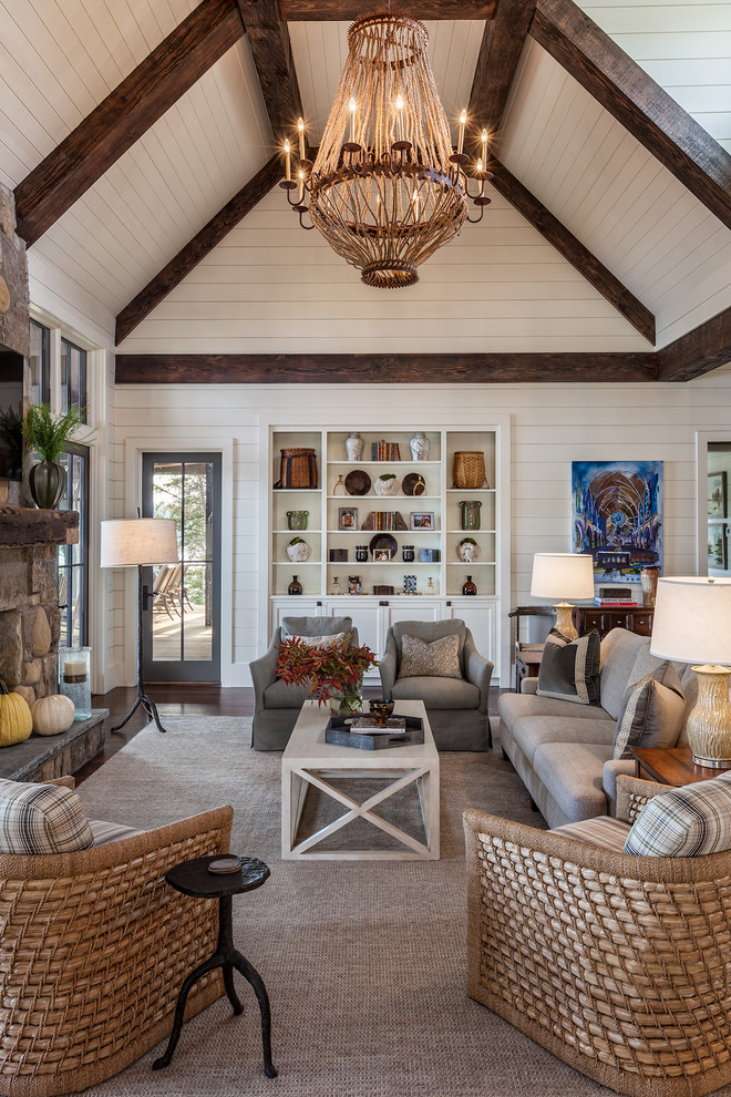 Example of a large farmhouse open concept dark wood floor and brown floor family room design in Other with white walls, a standard fireplace, a stone fireplace and a wall-mounted tv