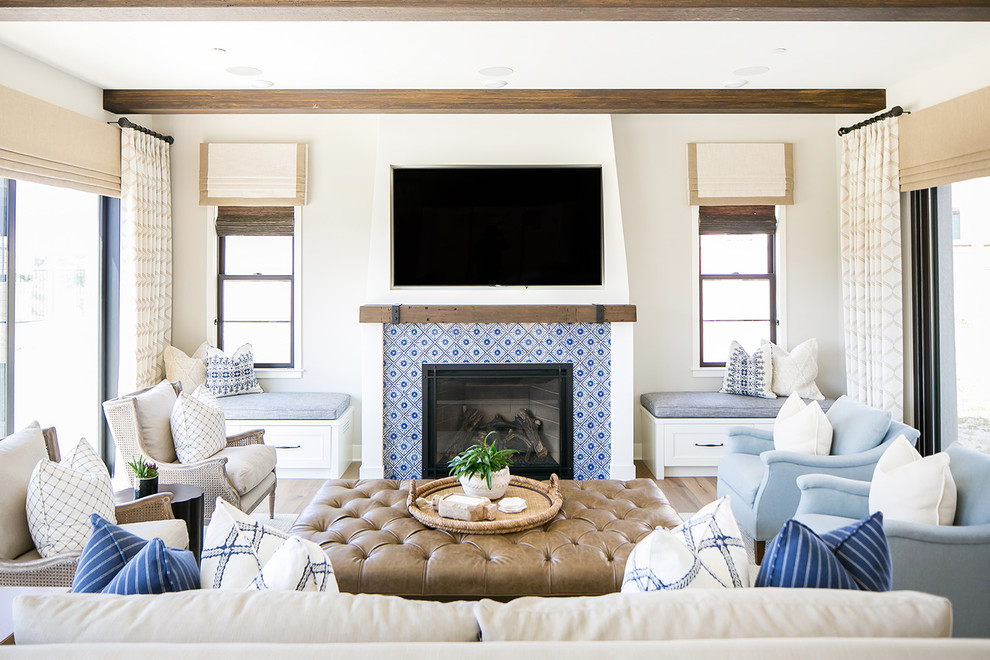 Стильный дизайн: гостиная комната в морском стиле с серыми стенами, паркетным полом среднего тона, стандартным камином, фасадом камина из плитки и телевизором на стене - последний тренд