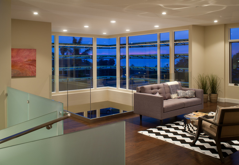 Imagen de sala de estar tipo loft contemporánea de tamaño medio con paredes beige, suelo de madera oscura, marco de chimenea de piedra y televisor retractable