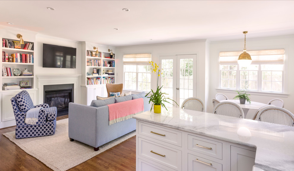 Offenes Klassisches Wohnzimmer mit weißer Wandfarbe, braunem Holzboden, Kamin, Kaminumrandung aus Stein und braunem Boden in Sonstige