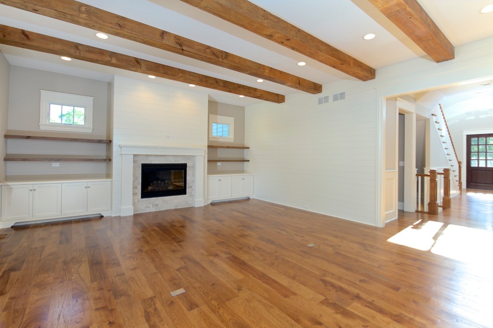 Großes, Abgetrenntes Klassisches Wohnzimmer mit grauer Wandfarbe, hellem Holzboden, Kamin, Kaminumrandung aus Holz und braunem Boden in Chicago