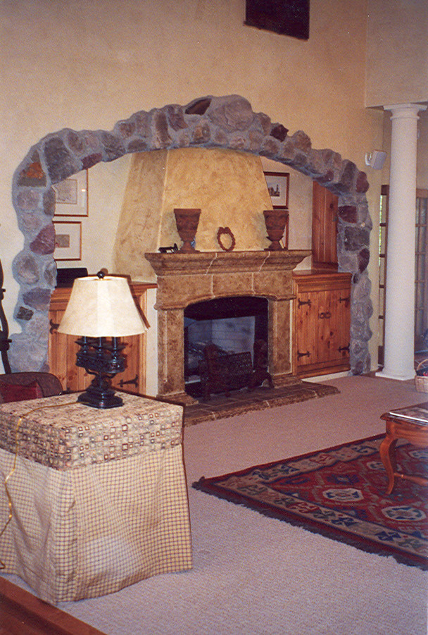 Cette image montre une salle de séjour méditerranéenne de taille moyenne et ouverte avec un mur beige, moquette, une cheminée standard, un manteau de cheminée en pierre et un téléviseur dissimulé.
