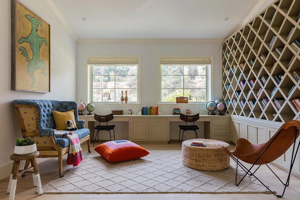 Imagen de sala de estar con biblioteca cerrada de estilo de casa de campo extra grande sin televisor con paredes beige, suelo de madera clara y suelo beige