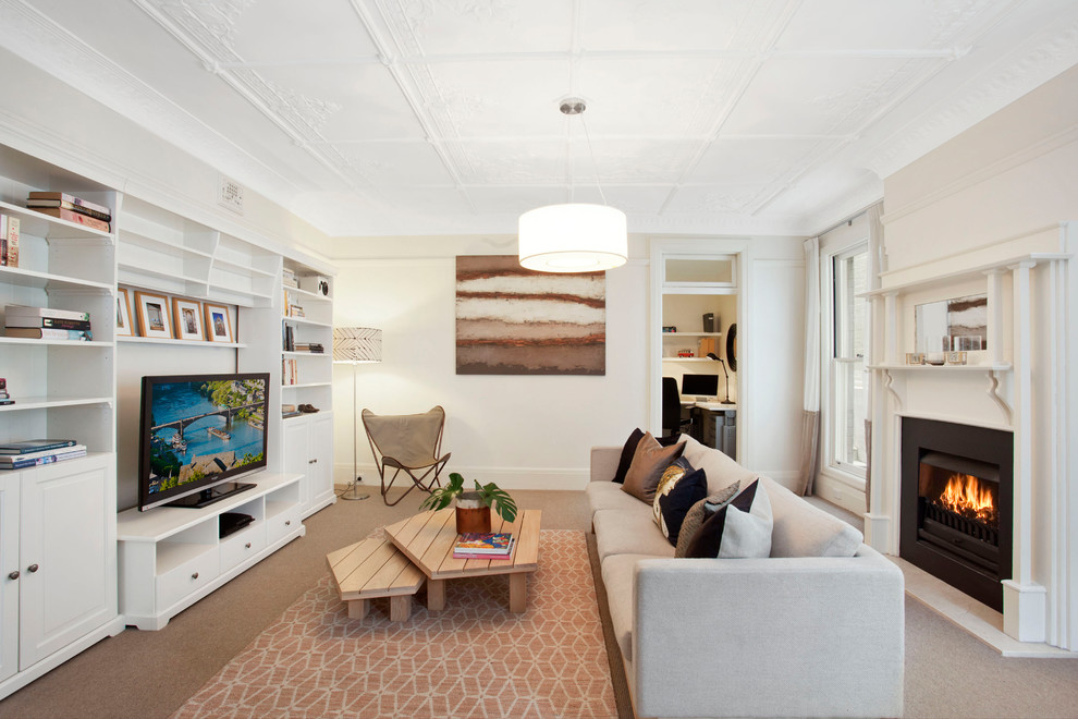 This is an example of a traditional enclosed games room in Sydney with a standard fireplace, a freestanding tv, white walls, carpet, a plastered fireplace surround and brown floors.