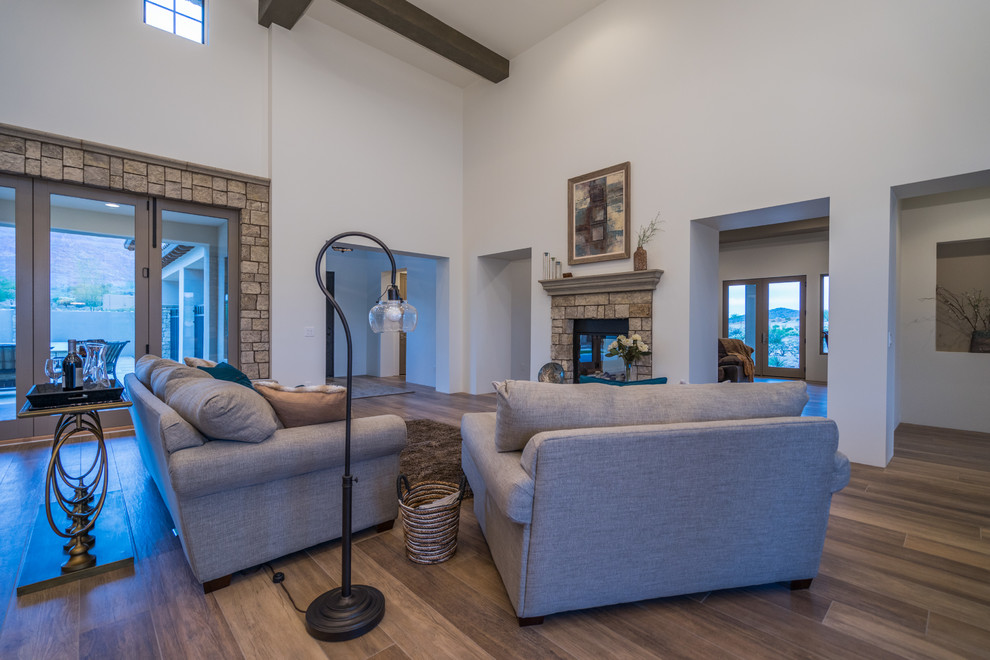 Imagen de sala de estar abierta clásica con suelo de baldosas de porcelana, chimenea de doble cara y marco de chimenea de piedra