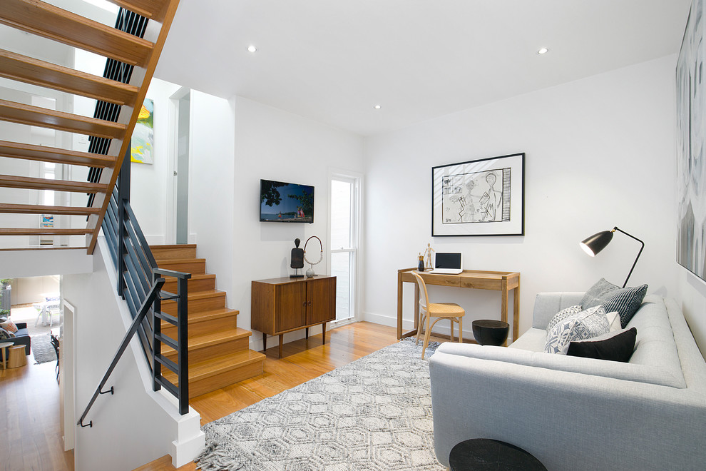Foto di un soggiorno design aperto con pareti bianche, pavimento in legno massello medio, nessun camino, TV a parete e pavimento marrone