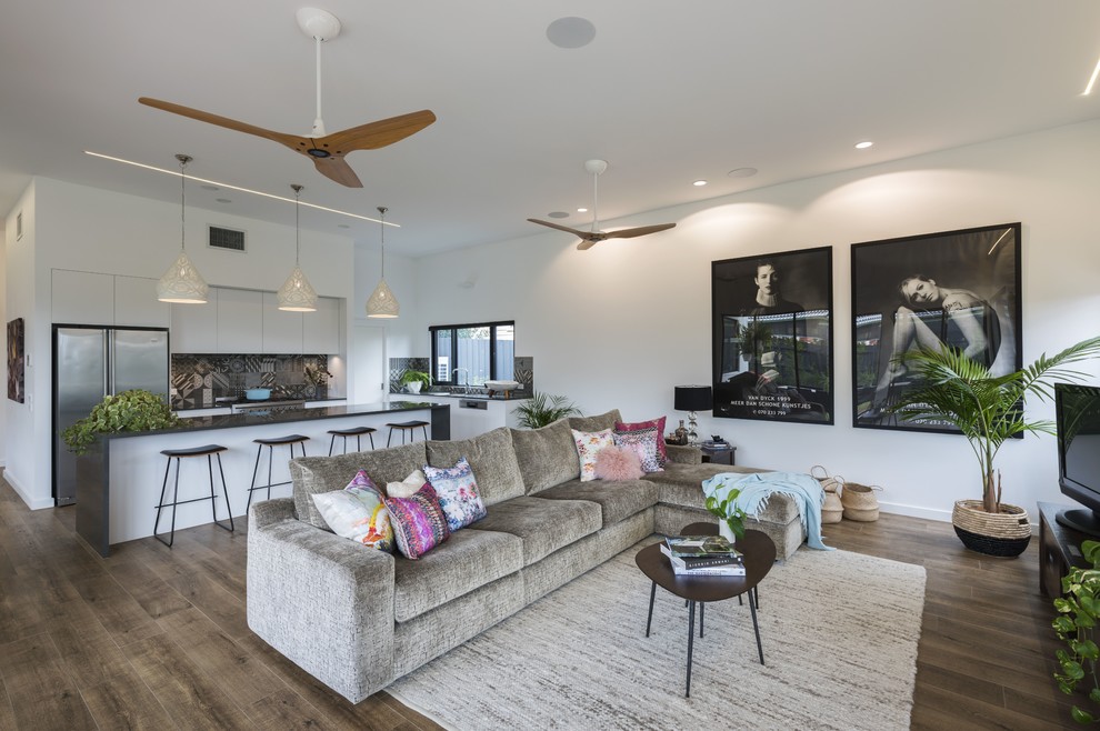 Diseño de sala de estar abierta actual con paredes blancas, suelo de baldosas de porcelana, televisor independiente y suelo marrón