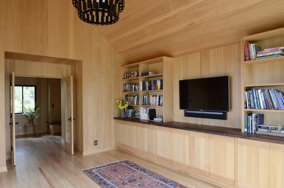 Esempio di un soggiorno minimal di medie dimensioni e chiuso con libreria, pareti marroni, parquet chiaro, TV a parete e pavimento marrone