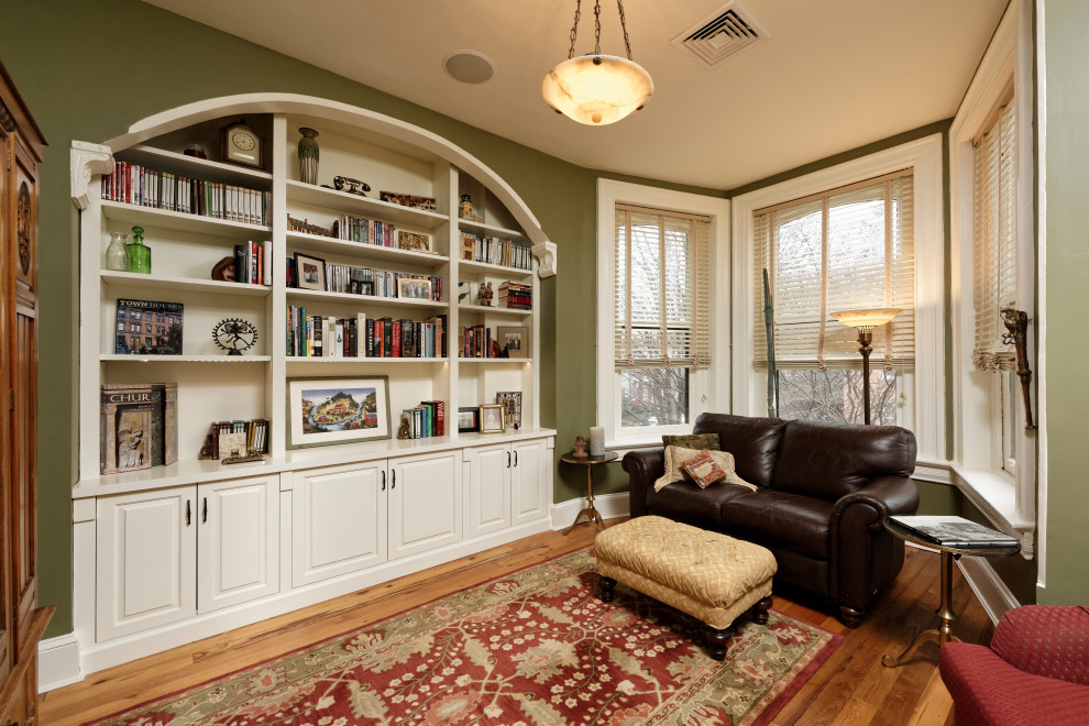 Imagen de salón cerrado tradicional con paredes verdes, suelo de madera en tonos medios y suelo marrón