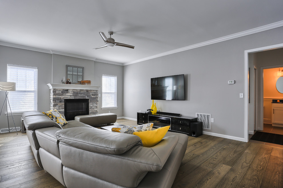 На фото: открытая гостиная комната среднего размера в стиле модернизм с серыми стенами, паркетным полом среднего тона, стандартным камином, фасадом камина из камня и телевизором на стене