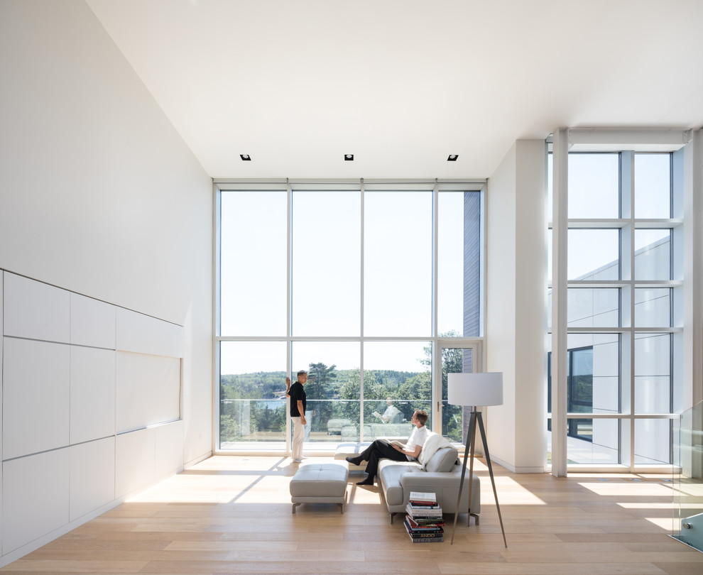Пример оригинального дизайна: открытая гостиная комната в стиле модернизм с белыми стенами, светлым паркетным полом, скрытым телевизором и бежевым полом без камина