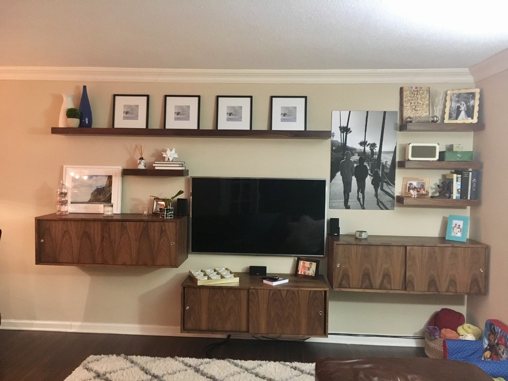 Foto de sala de estar abierta contemporánea de tamaño medio sin chimenea con paredes beige, suelo de madera oscura y pared multimedia