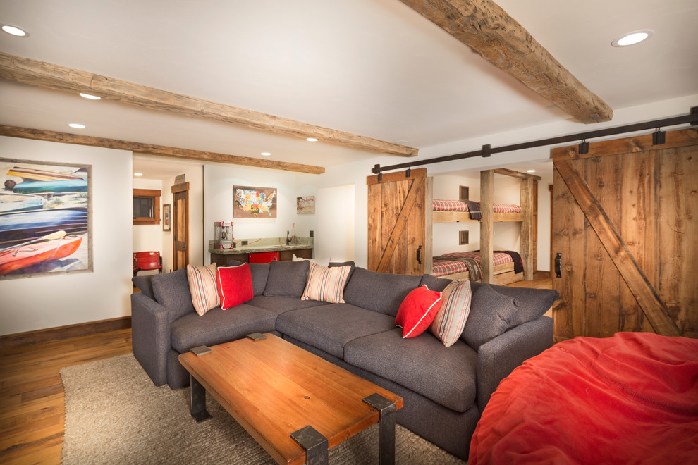 Diseño de sala de estar cerrada rural grande con paredes beige, suelo de madera en tonos medios y pared multimedia