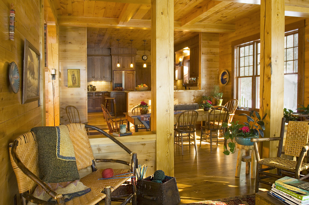Пример оригинального дизайна: открытая гостиная комната в стиле рустика с с книжными шкафами и полками, коричневыми стенами и светлым паркетным полом