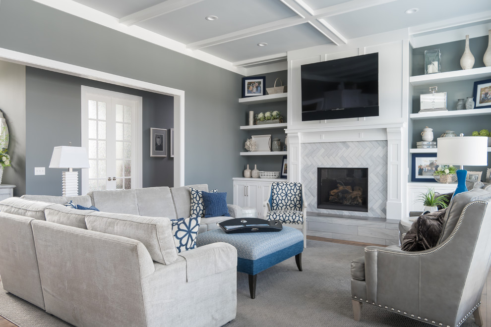 This is an example of a traditional games room in Grand Rapids with grey walls, a standard fireplace, a tiled fireplace surround, a wall mounted tv and feature lighting.