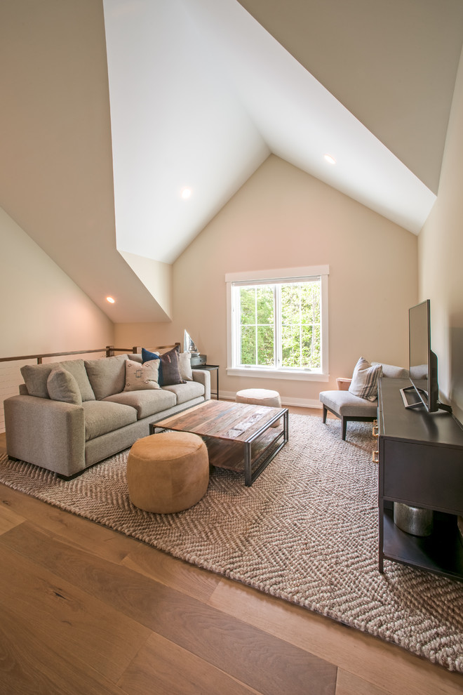 Diseño de sala de estar tipo loft de estilo de casa de campo con paredes beige, suelo de madera clara, televisor independiente, suelo marrón y alfombra