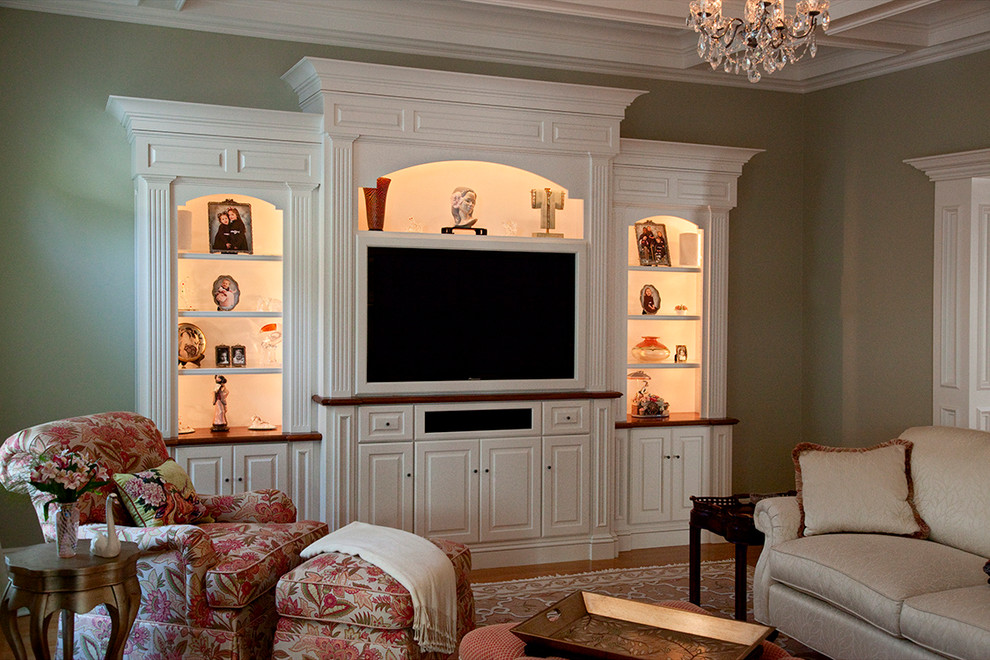 Modelo de sala de estar cerrada clásica de tamaño medio con paredes verdes, suelo de madera en tonos medios, pared multimedia y suelo marrón