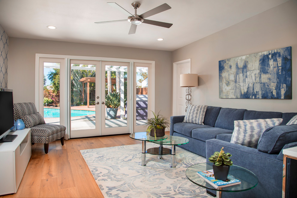 Mittelgroßes, Offenes Klassisches Wohnzimmer ohne Kamin mit grauer Wandfarbe, braunem Holzboden und freistehendem TV in San Diego