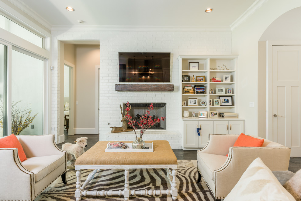 Mittelgroßes, Offenes Klassisches Wohnzimmer mit weißer Wandfarbe, dunklem Holzboden, Kamin, TV-Wand und Kaminumrandung aus Backstein in Austin