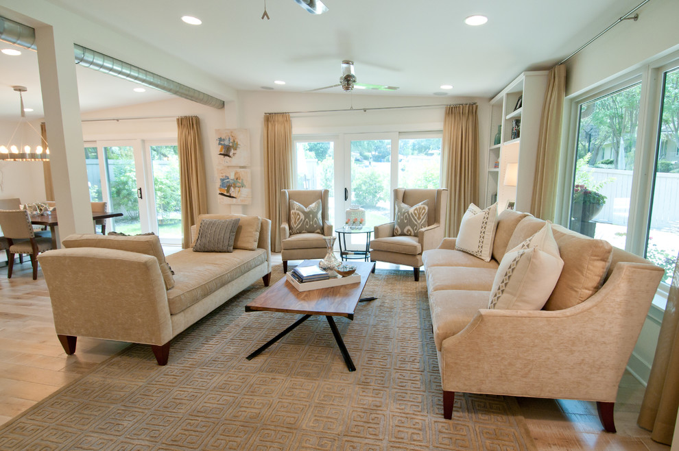 Imagen de sala de estar abierta actual con paredes beige y suelo de madera clara