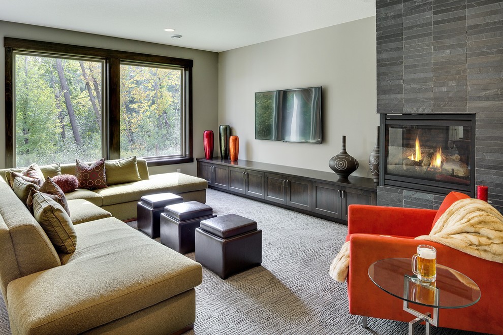 Inspiration for a large traditional open plan games room in Minneapolis with beige walls, carpet, a corner fireplace, a stone fireplace surround, a wall mounted tv and grey floors.