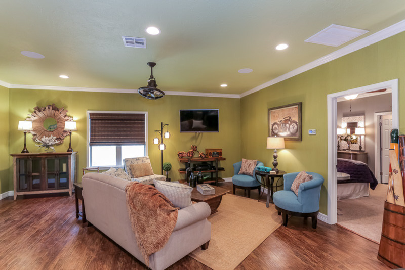 Großes, Offenes Stilmix Wohnzimmer mit grüner Wandfarbe, braunem Holzboden und TV-Wand in Houston