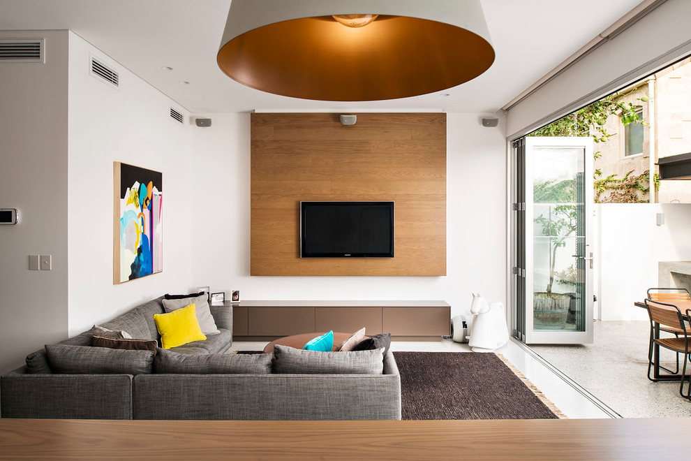 Пример оригинального дизайна: открытая, парадная гостиная комната в современном стиле с белыми стенами и телевизором на стене без камина