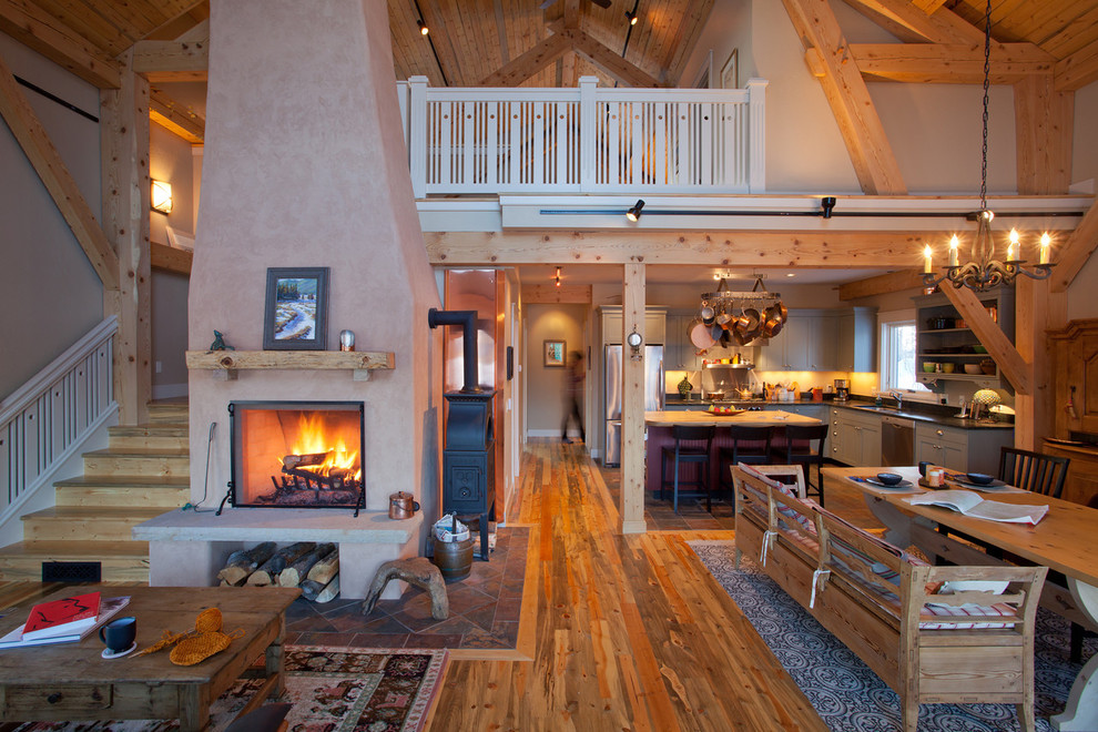 Foto de sala de estar abierta rural con paredes beige, suelo de madera en tonos medios, todas las chimeneas y suelo marrón