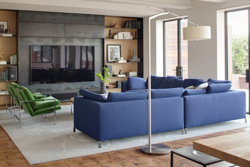 Идея дизайна: большая гостиная комната в современном стиле с белыми стенами, мультимедийным центром и синим диваном без камина