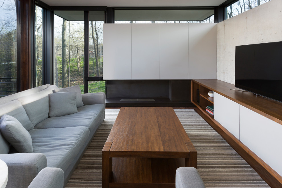 Пример оригинального дизайна: маленькая открытая гостиная комната в стиле модернизм с разноцветными стенами, отдельно стоящим телевизором и коричневым полом для на участке и в саду
