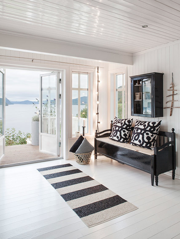 Mittelgroßer, Abgetrennter Moderner Hobbyraum mit weißer Wandfarbe, gebeiztem Holzboden, Kamin, Kaminumrandung aus Holz und Eck-TV in Sonstige