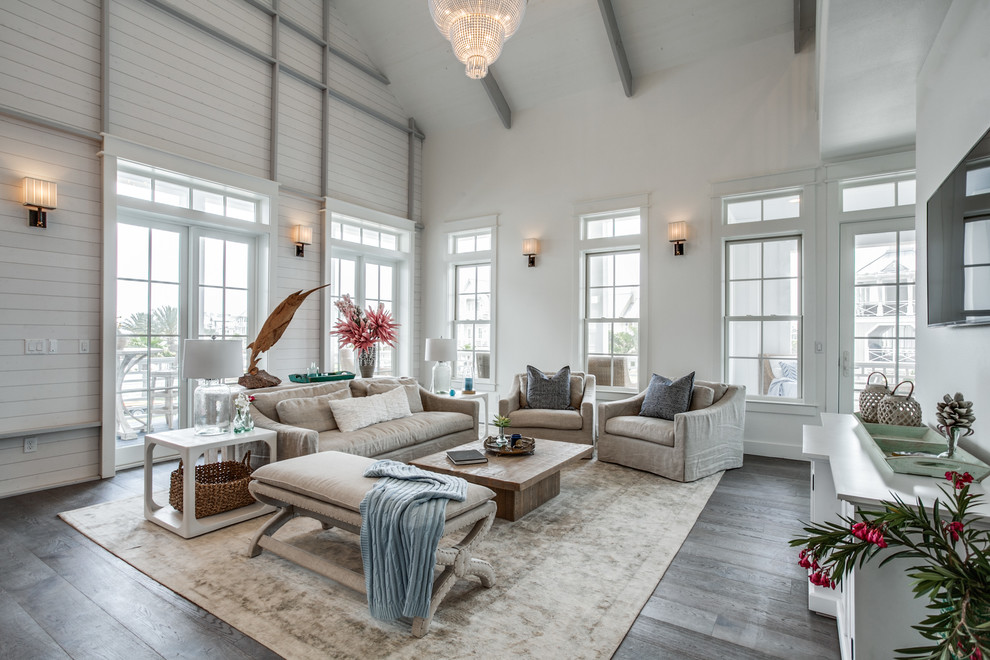 Maritimes Wohnzimmer mit weißer Wandfarbe, dunklem Holzboden, TV-Wand und grauem Boden in Austin