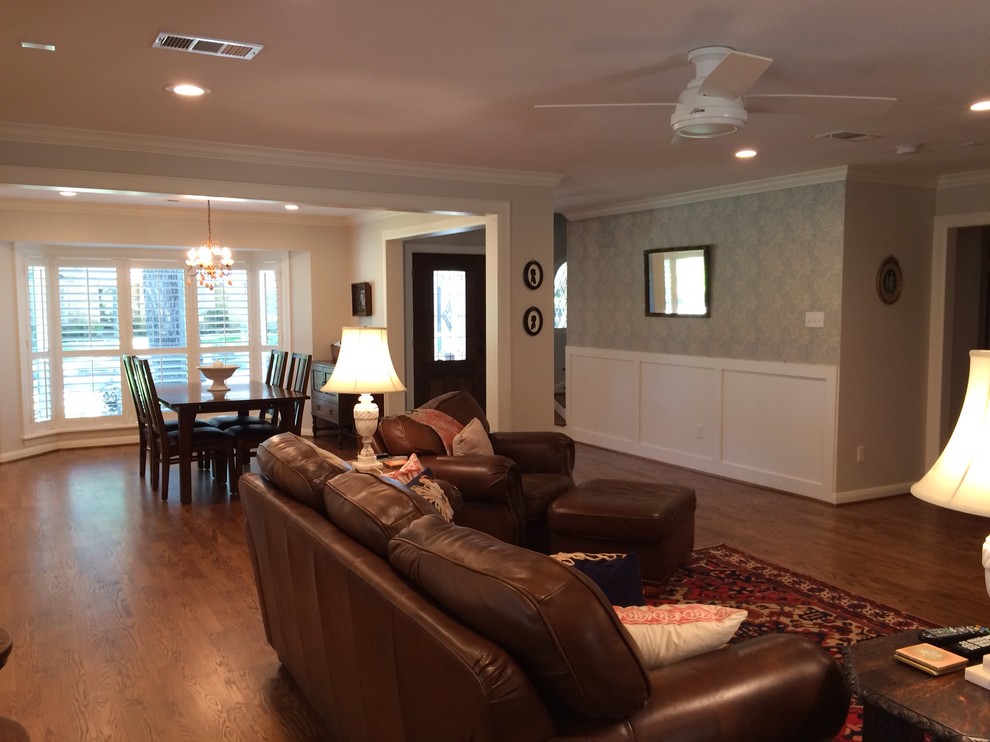 Ejemplo de sala de estar abierta tradicional de tamaño medio con paredes blancas, suelo de madera en tonos medios, chimenea de esquina, marco de chimenea de ladrillo y pared multimedia