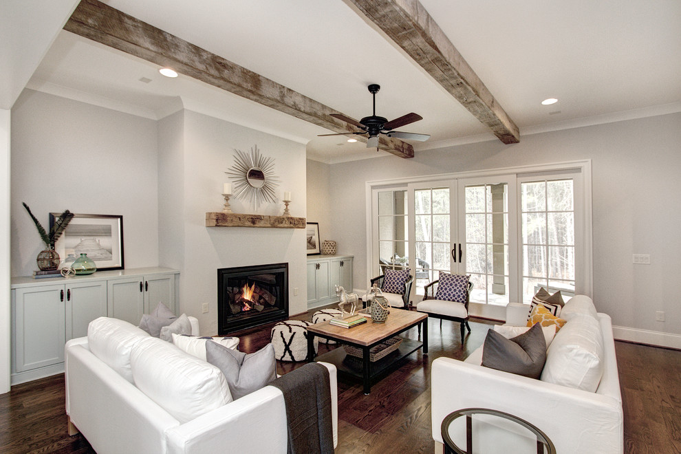 This is an example of a large classic open plan games room in Charlotte with grey walls, dark hardwood flooring, a standard fireplace, a plastered fireplace surround and no tv.