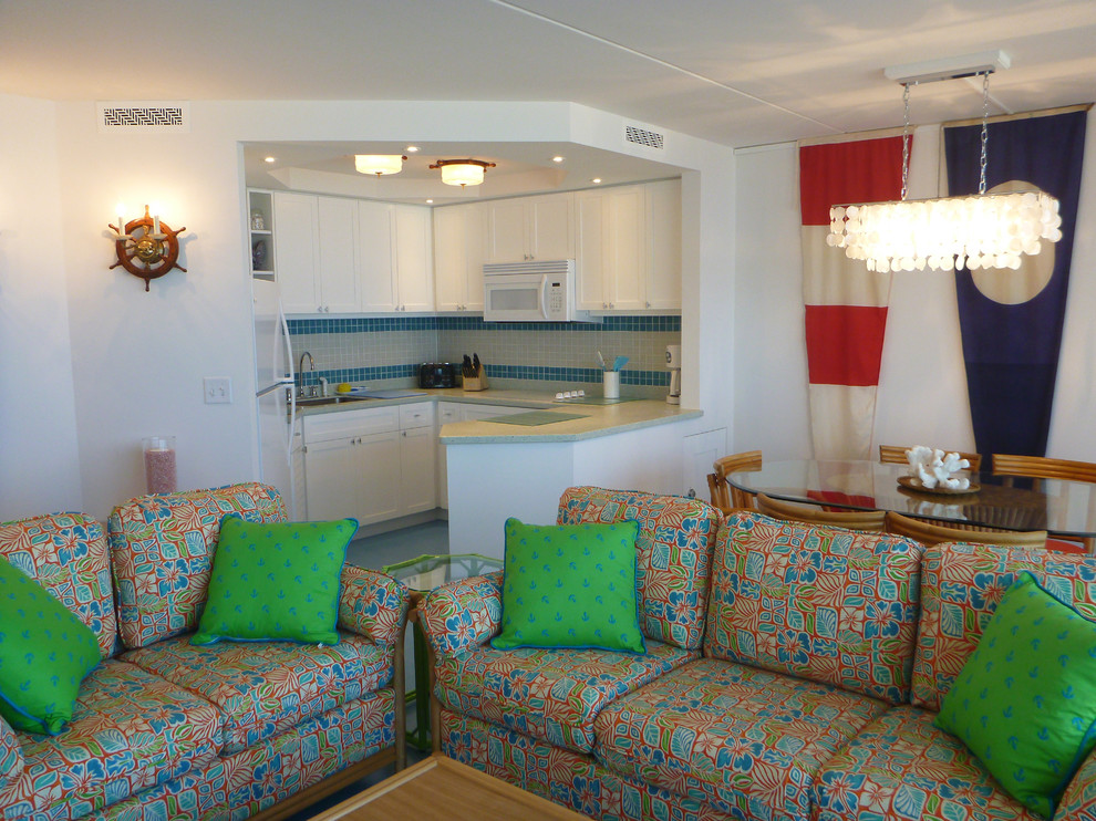 Exemple d'une petite salle de séjour bord de mer ouverte avec un mur blanc, aucune cheminée et un téléviseur dissimulé.