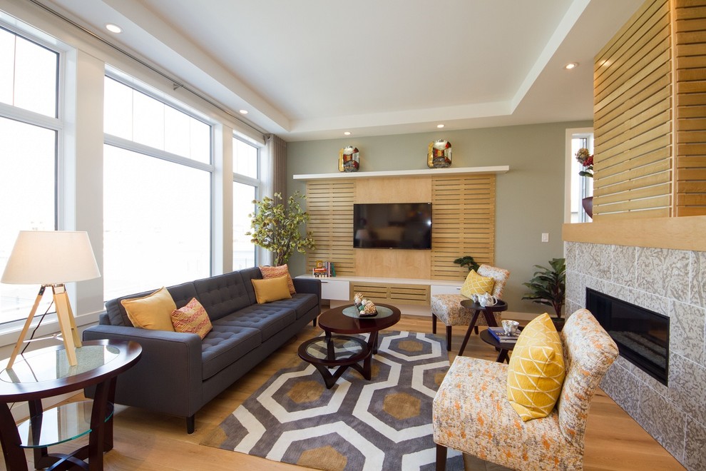 Стильный дизайн: открытая гостиная комната среднего размера в скандинавском стиле с зелеными стенами, светлым паркетным полом, двусторонним камином, фасадом камина из камня и телевизором на стене - последний тренд