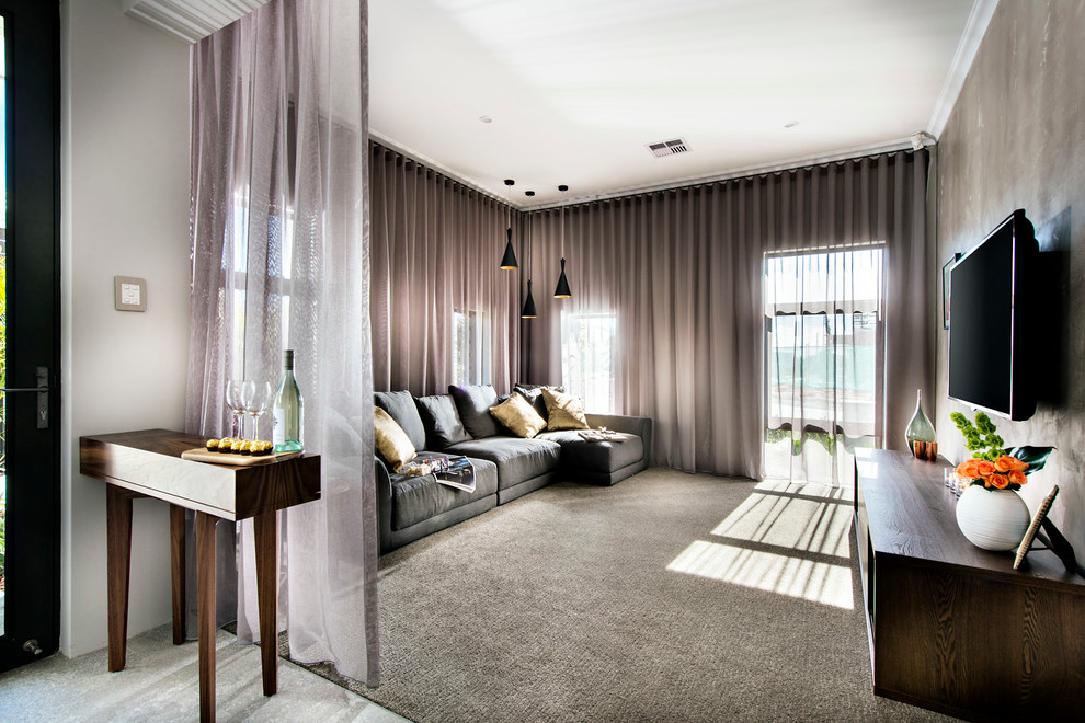 На фото: гостиная комната в современном стиле с серыми стенами, ковровым покрытием и телевизором на стене без камина
