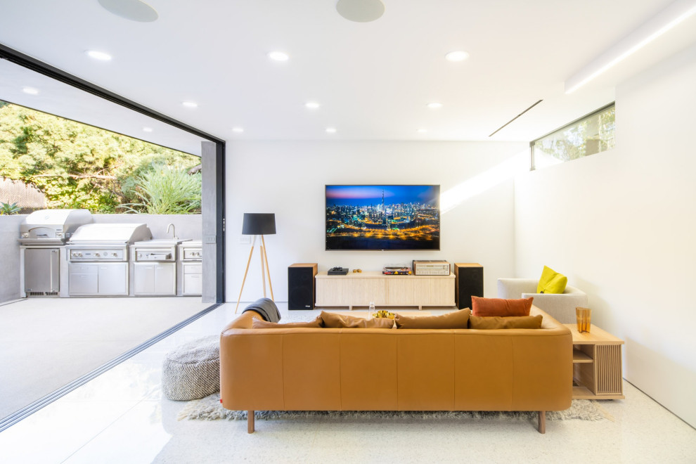 Esempio di un soggiorno minimalista con sala giochi, pareti bianche, TV a parete e pavimento bianco