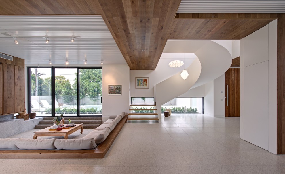 Offenes Modernes Wohnzimmer mit weißer Wandfarbe, Kamin und Kaminumrandung aus Stein in Melbourne