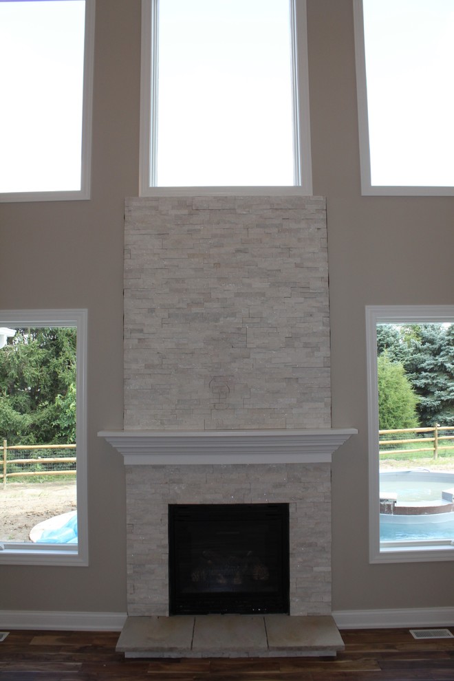 Ejemplo de sala de estar clásica con suelo de madera en tonos medios, todas las chimeneas y marco de chimenea de piedra