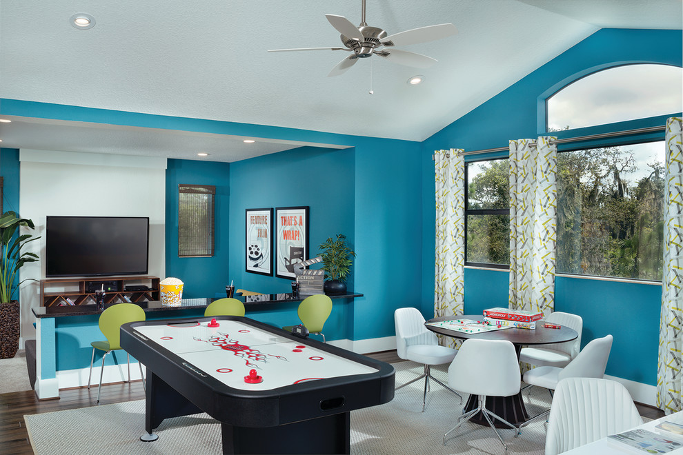Immagine di un grande soggiorno design aperto con sala giochi, pareti blu, pavimento in legno massello medio, nessun camino e TV a parete