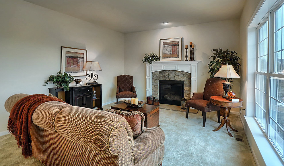 This is an example of a medium sized classic enclosed games room in Philadelphia with beige walls, carpet, a standard fireplace, a stone fireplace surround, no tv and beige floors.