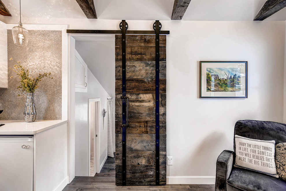 Foto de sala de estar abierta rústica pequeña con paredes grises, suelo de madera en tonos medios, todas las chimeneas y televisor colgado en la pared