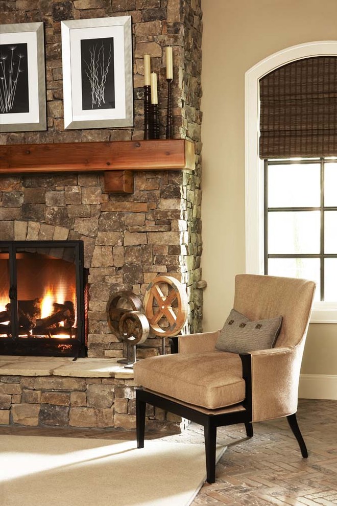 他の地域にあるラグジュアリーな広いコンテンポラリースタイルのおしゃれなオープンリビング (ベージュの壁、レンガの床、標準型暖炉、石材の暖炉まわり) の写真